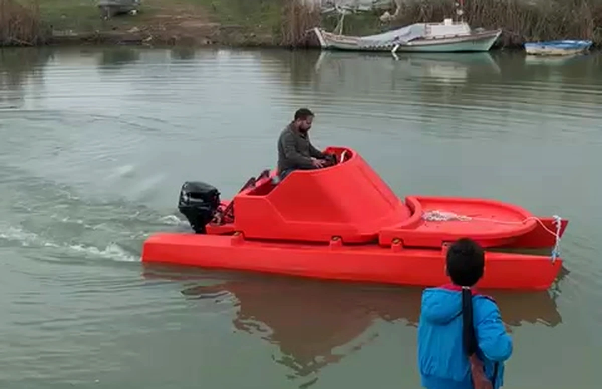 Üretim sonrası su testinde kanalda hareket eden kırmızı katamaran